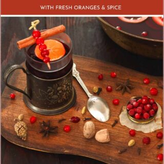 cranberries, mug of cranberry punch, oranges on a table