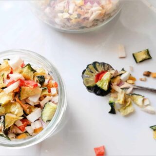 freeze dried chopped veggies in a cup on a counter with a spoon