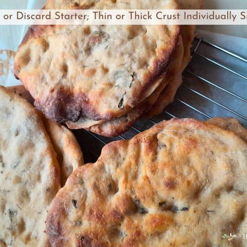 sourdough mini pizza crusts stacked on a baking rack