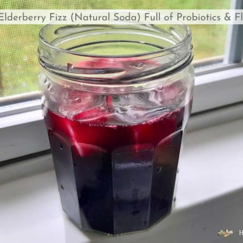 glass of elderberry fizz sitting on a windowsill