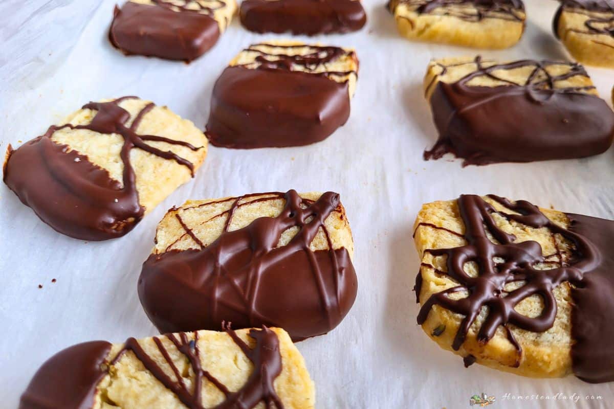 chocolate dipped lavender sourdough shortbread cookies on parchment paper