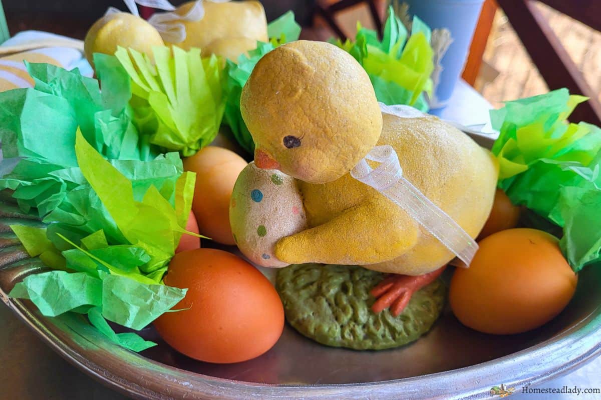 homemade confetti eggs that look like carrots on a table with an Easter chick